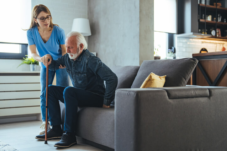 Caregiver helping senior with safe movement at home.